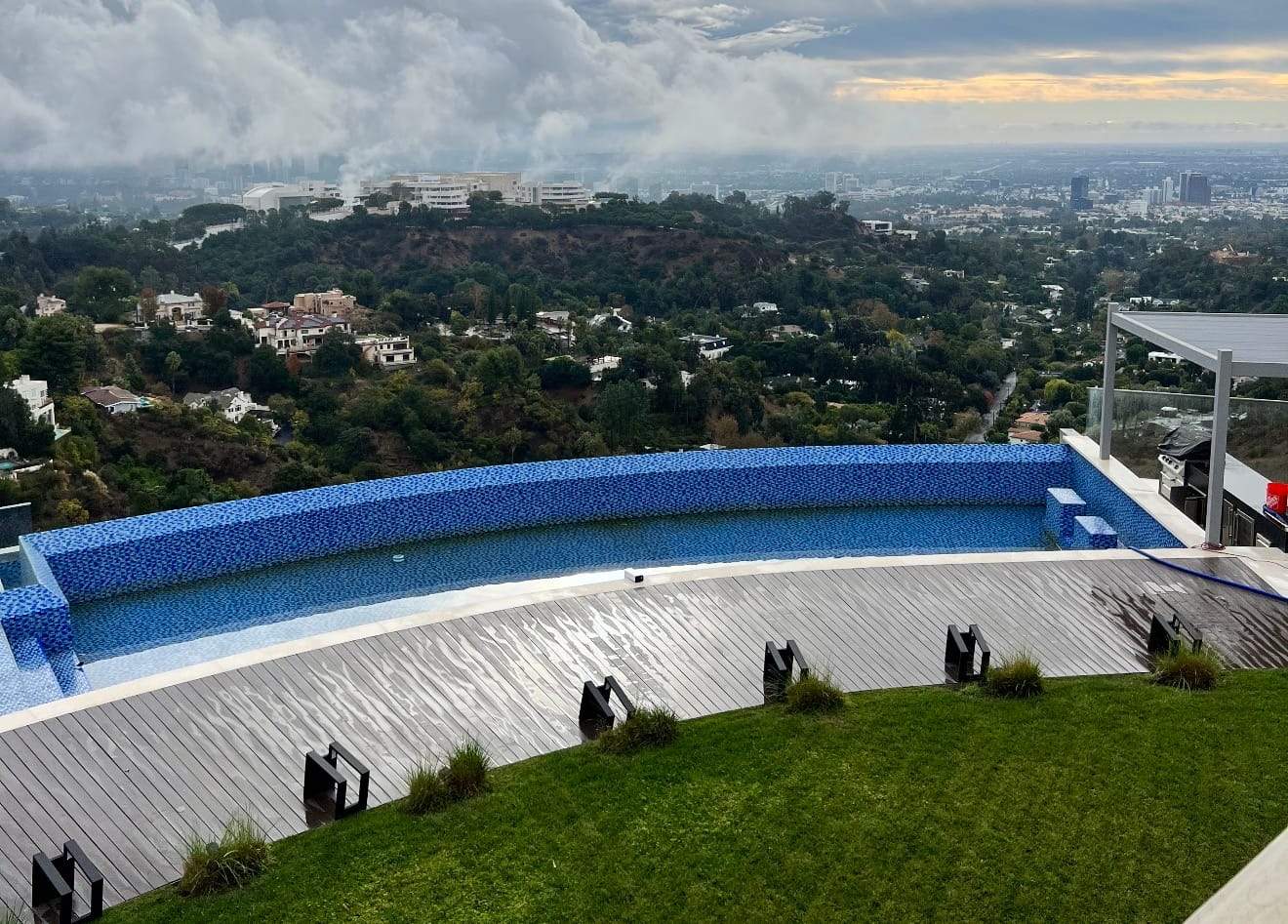 Hillside infinity pool with blue mosaic tile before demolition